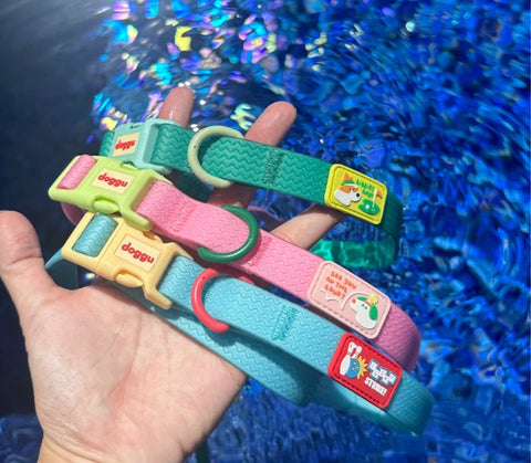 Doggu Sport Club waterproof dog collars in pink, green and blue held in hand, showing the sport patches